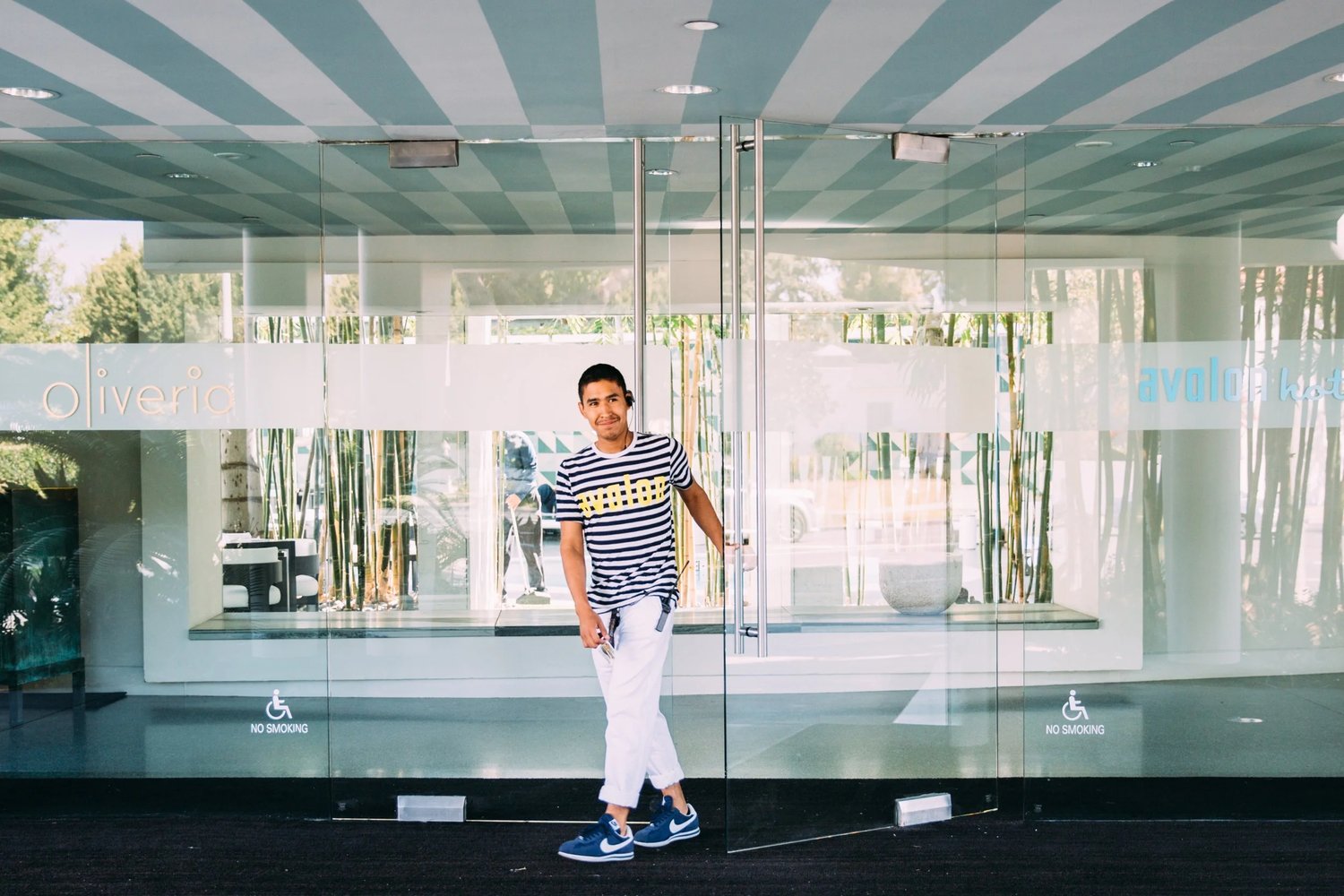 Bellhop wearing white blue striped hospitality mens uniform for avalon beverly hills by finery.
