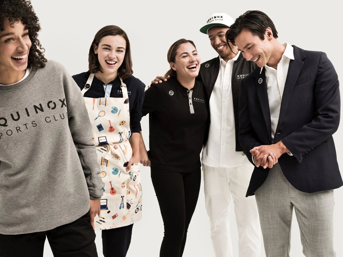 A group of Equinox employees wearing bespoke uniforms by Finery.