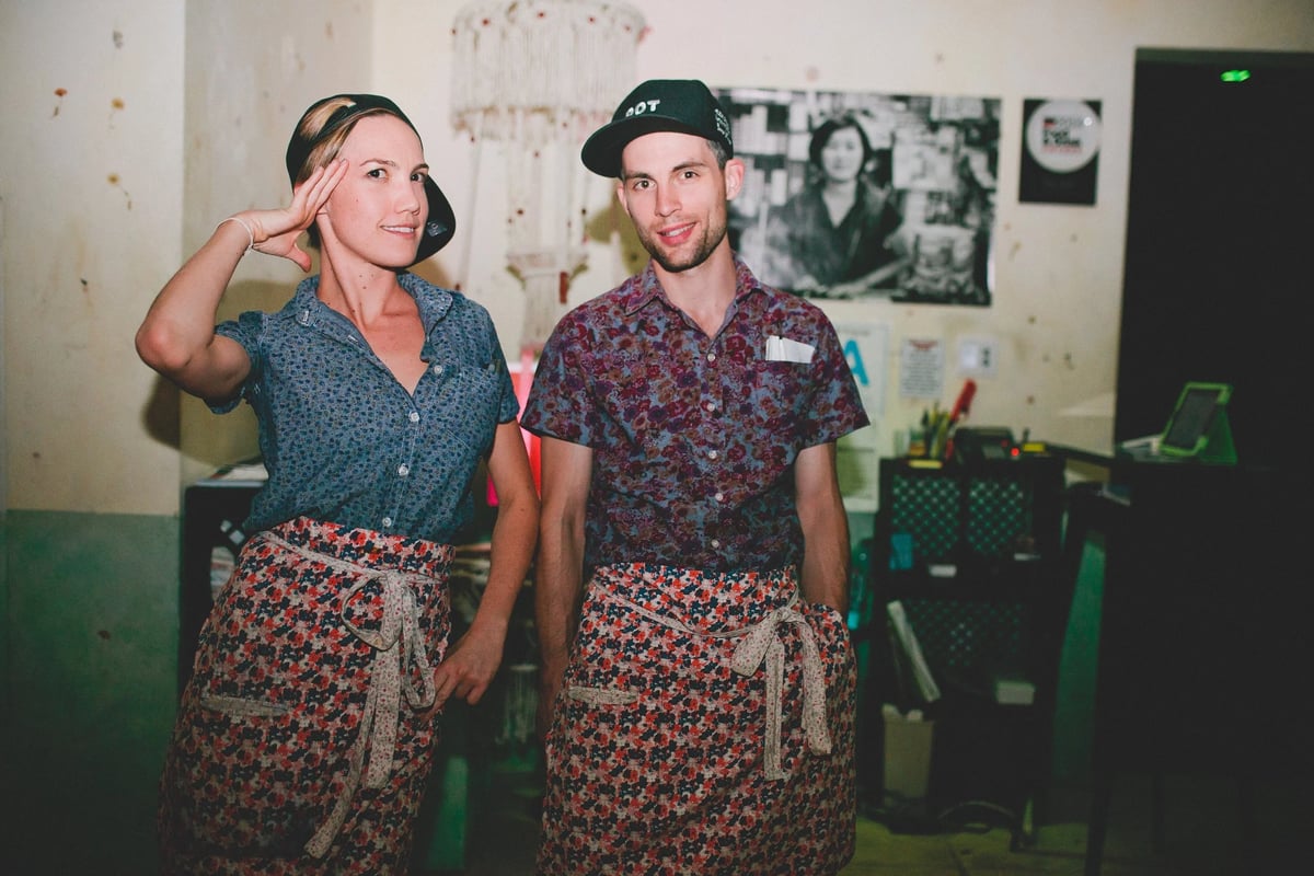 Two servers wearing a floral half apron uniform for Roy Choi by Finery.