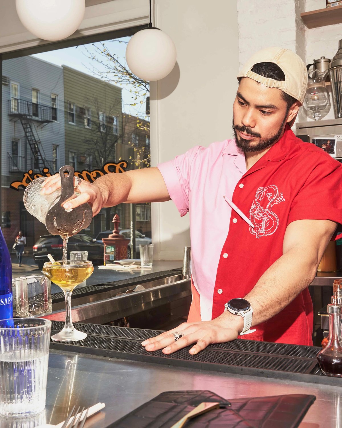 Calvin Eng pouring drink wearing Bonnie's custom two color shirt uniform by Finery.