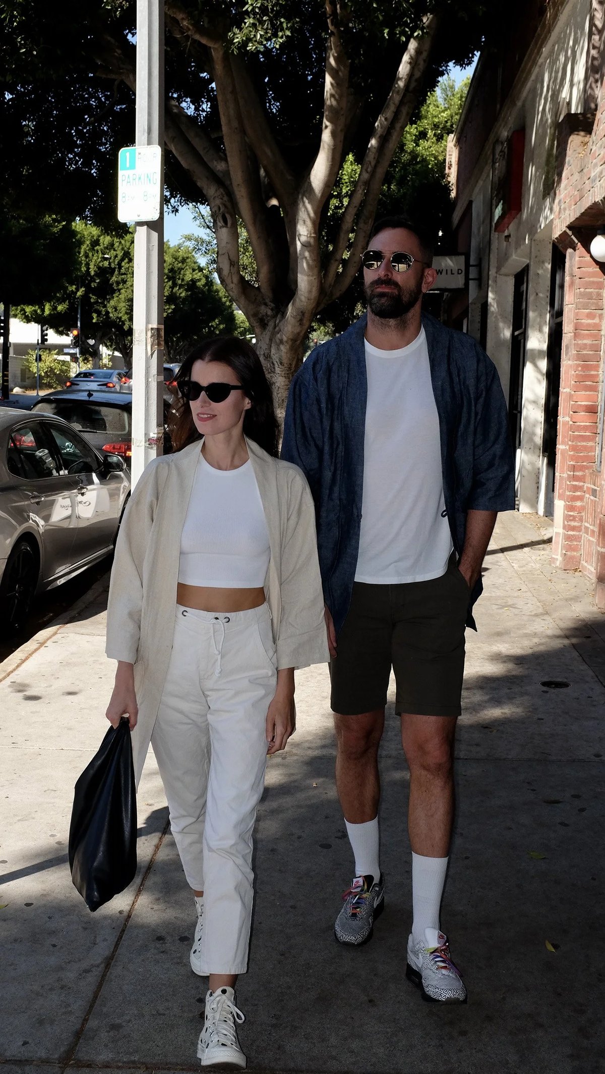 A pair walking wearing Proper Hotels kimono coat in oatmeal and indigo designed by Finery.