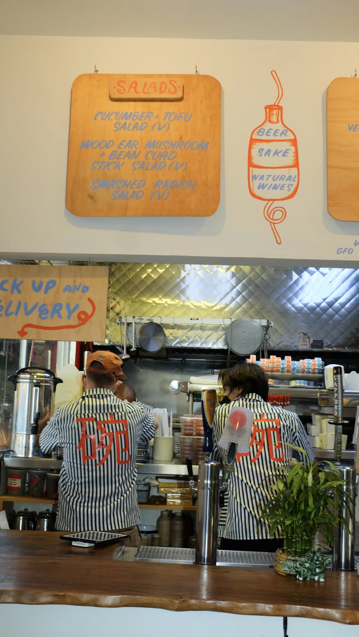 Keegan and Mama Fong working in Woon wearing custom Woon work shirt uniform designed by Finery.